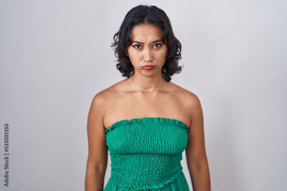 Fototapeta premium Young hispanic woman standing over isolated background depressed and worry for distress, crying angry and afraid. sad expression.