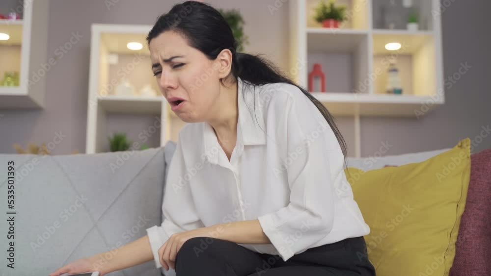 Coughing woman at home.
The woman looking at her phone starts to cough and this cough continues for a long time.
