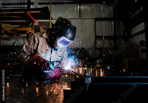 Industrial welder with torch MIG welding metal in a manufacturing factory  photo