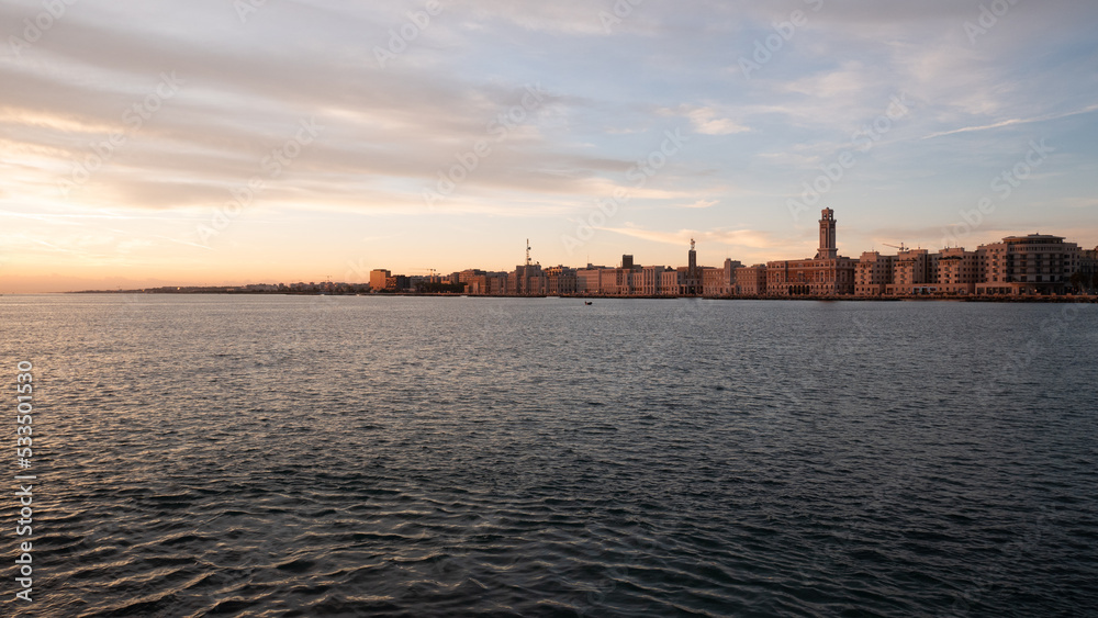 Bari, Alba vista dal Molo di Sant Antonio profilo lungomare, nave, profilo della città, barche sorgere del sole, nuvole