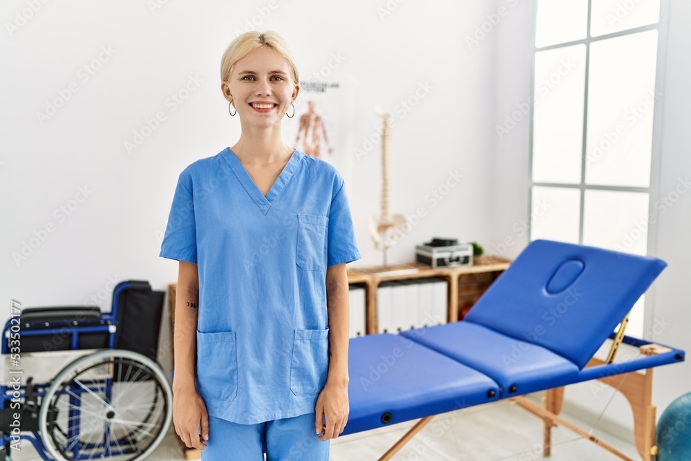 Beautiful caucasian physiotherapist woman working at pain recovery clinic with a happy and cool smile on face. lucky person.