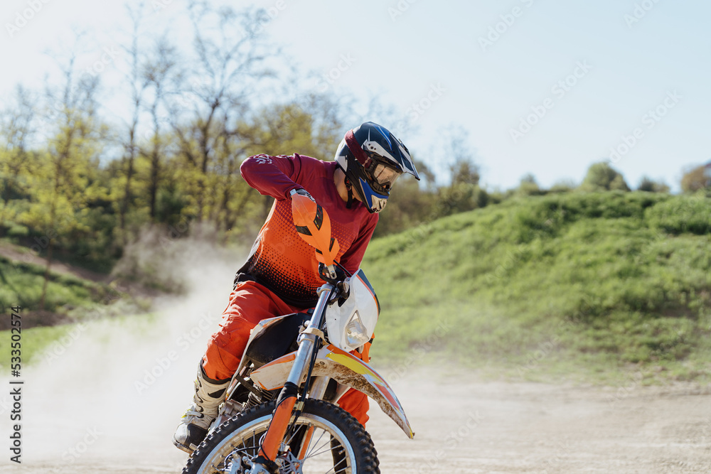 Naklejka premium Extreme and Adrenaline. Motocross rider in action. Motocross sport. Active lifestyle. Flying dust.