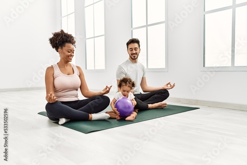 Couple and daughter smiling confident training yoga at sport center