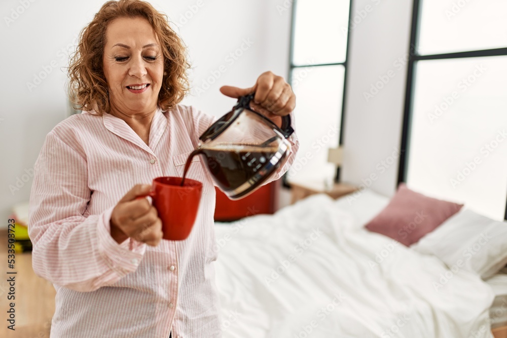 Middle age caucasian woman drinking coffee standing at bedroom. Middle age caucasian woman drinking coffee standing at bedroom.