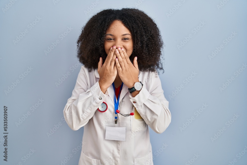 Young african american woman wearing doctor uniform and stethoscope laughing and embarrassed giggle covering mouth with hands, gossip and scandal concept Young african american woman wearing doctor uniform and stethoscope laughing and embarrassed giggle covering mouth with hands, gossip and scandal concept
