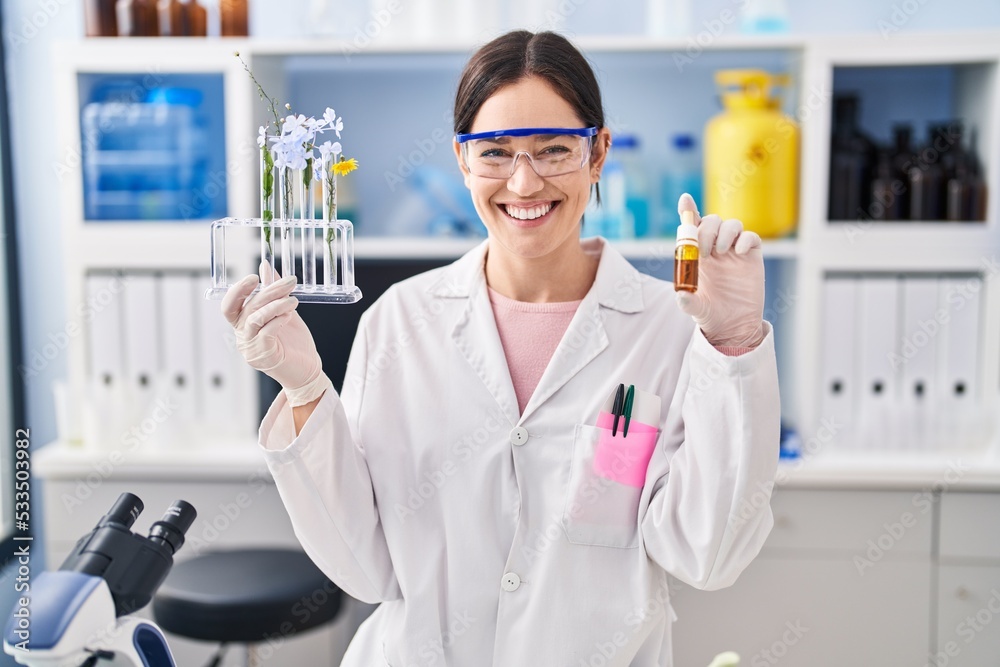 Young brunette woman working at scientist laboratory smiling with a happy and cool smile on face. showing teeth.