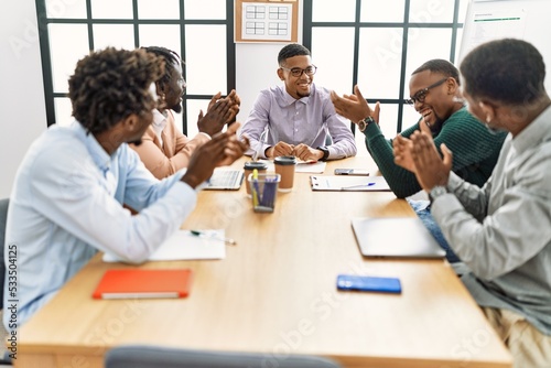 Group of african american business workers smiling and clapping to partner at the office.