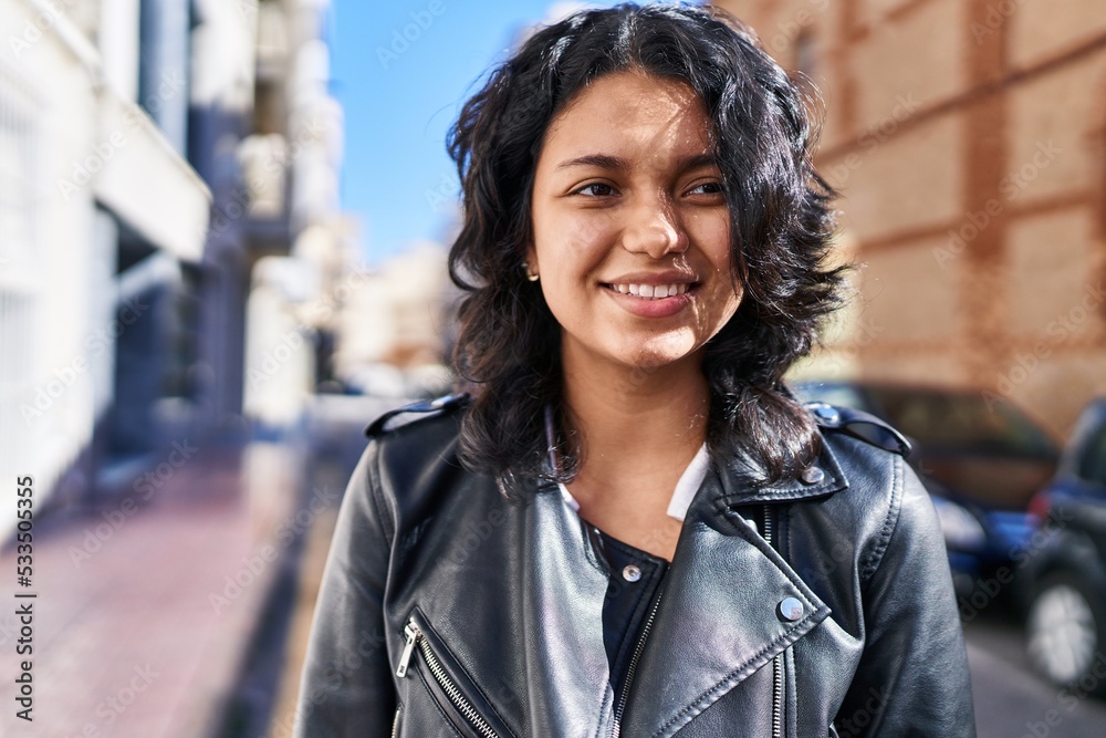 Young latin woman smiling confident looking to the side at street Young latin woman smiling confident looking to the side at street