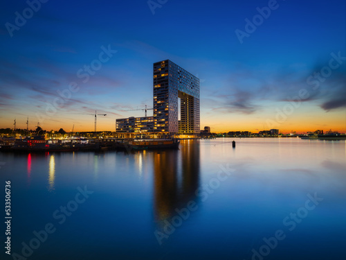 Amsterdam, Netherlands. A skyscraper and business center in the bay. A cityscape in the evening. Architecture of the Netherlands.