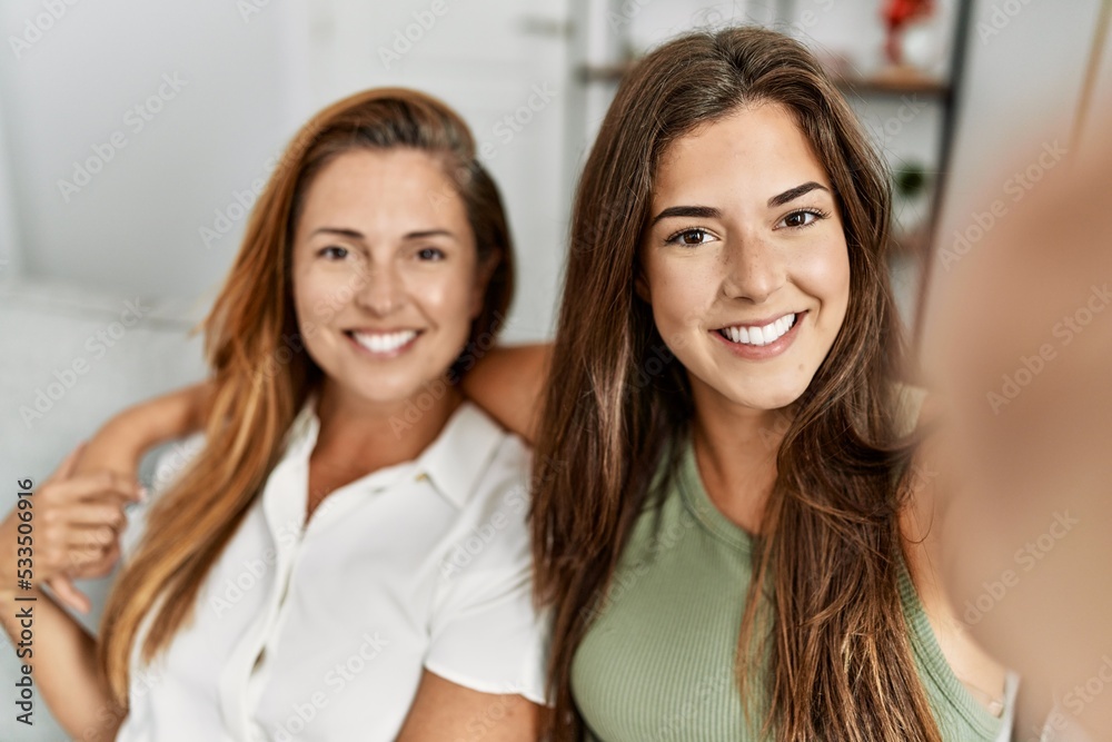 Mother and daughter smiling confident and hugging each other making selfie by the camera at home Mother and daughter smiling confident and hugging each other making selfie by the camera at home