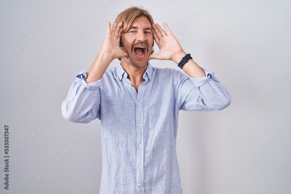 Caucasian man with mustache standing over white background smiling cheerful playing peek a boo with hands showing face. surprised and exited Caucasian man with mustache standing over white background smiling cheerful playing peek a boo with hands showing face. surprised and exited