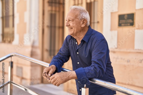 Print op canvas Senior grey-haired man smiling confident standing leaning on balustrade at stree