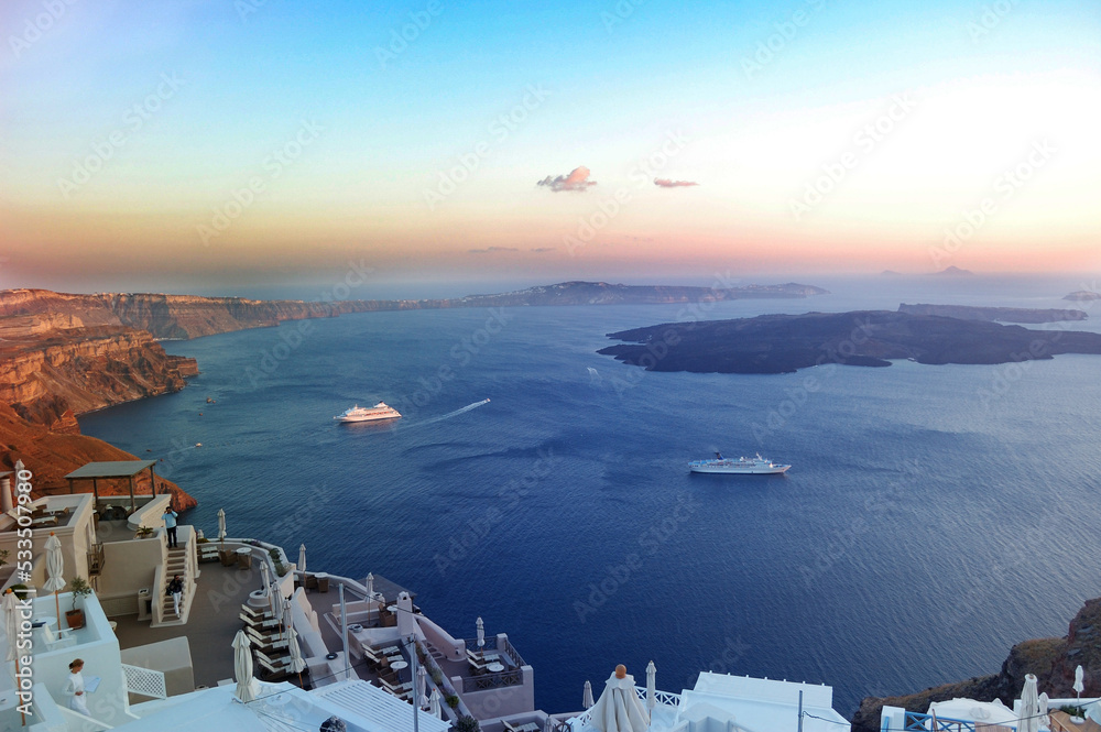 Fototapeta premium Santorini in the evening, Greece. View from the steep shore to the Mediterranean Sea in the evening, sunset over the sea. Filmed during a trip to the Mediterranean Sea and the Cycladic Archipelago.