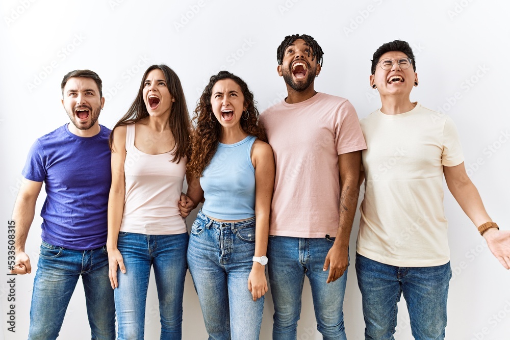 Group of young people standing together over isolated background angry and mad screaming frustrated and furious, shouting with anger. rage and aggressive concept. Group of young people standing together over isolated background angry and mad screaming frustrated and furious, shouting with anger. rage and aggressive concept.