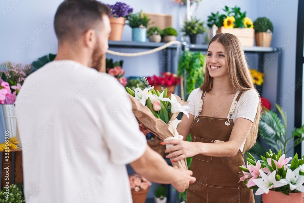 Man and woman customer buying bouquet of flowers at flower shop