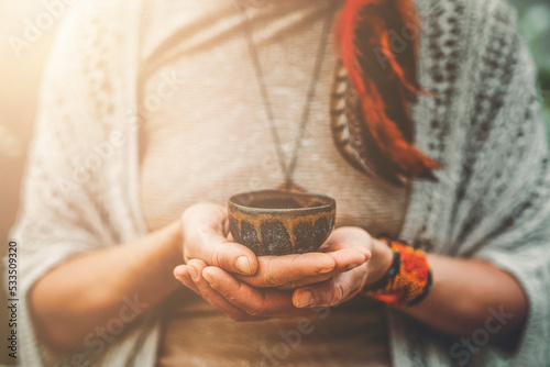 Cacao ceremony, heart opening medicine. Ceremony space. Cacao cup in woman's hand.