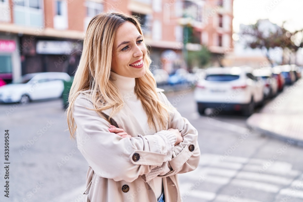Fototapeta premium Young blonde woman standing with arms crossed gesture at street