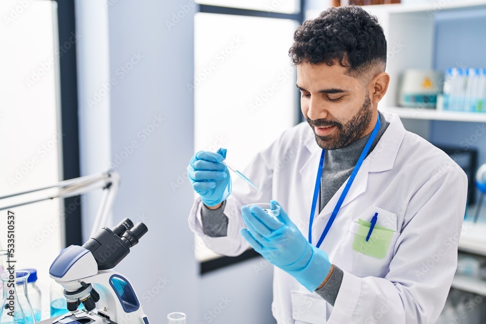 Young hispanic man wearing scientist uniform working at laboratory Young hispanic man wearing scientist uniform working at laboratory