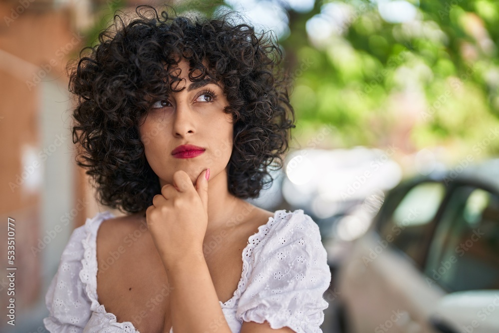 Fototapeta premium Young middle east woman standing with doubt expression at street