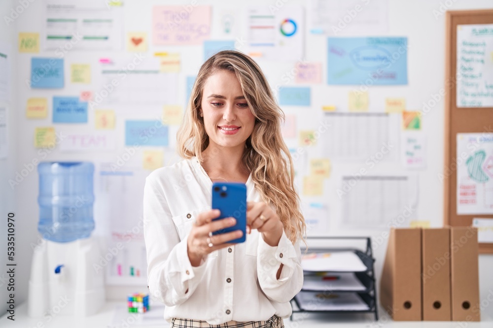 Young blonde woman business worker smiling confident using smartphone at office Young blonde woman business worker smiling confident using smartphone at office