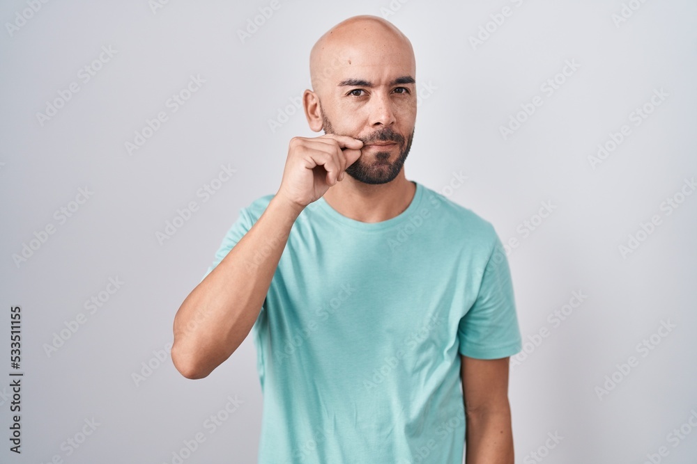 Middle age bald man standing over white background mouth and lips shut as zip with fingers. secret and silent, taboo talking Middle age bald man standing over white background mouth and lips shut as zip with fingers. secret and silent, taboo talking