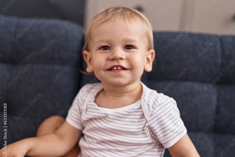 Adorable toddler smiling confident sitting on sofa at home