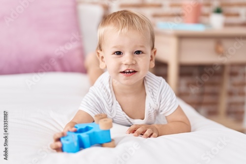 Adorable toddler smiling confident lying on bed at bedroom