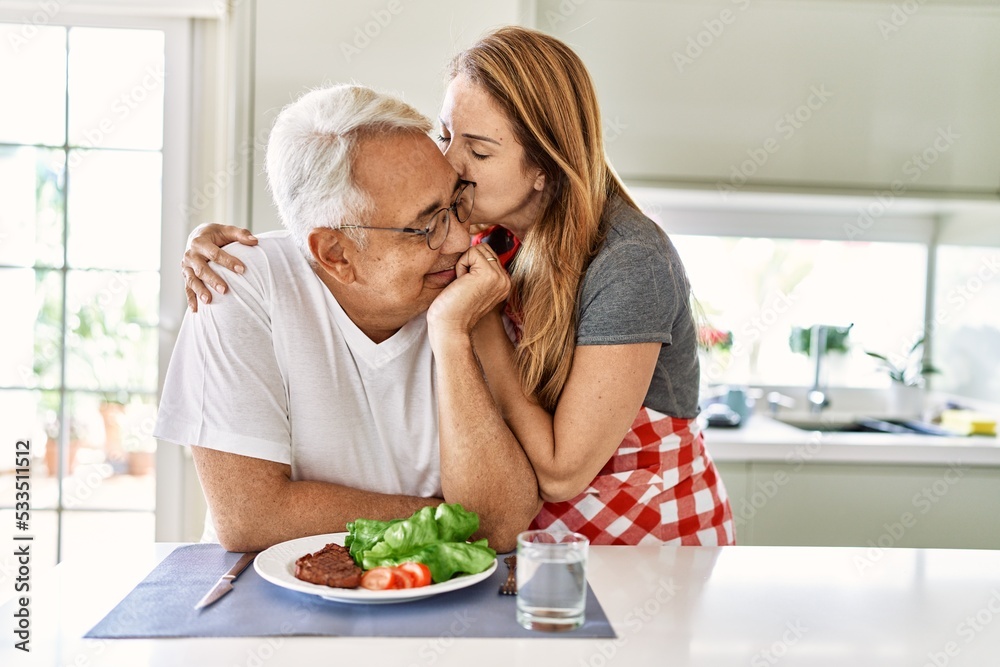 Middle age hispanic couple smiling happy eating beef with salad at the kitchen. Middle age hispanic couple smiling happy eating beef with salad at the kitchen.