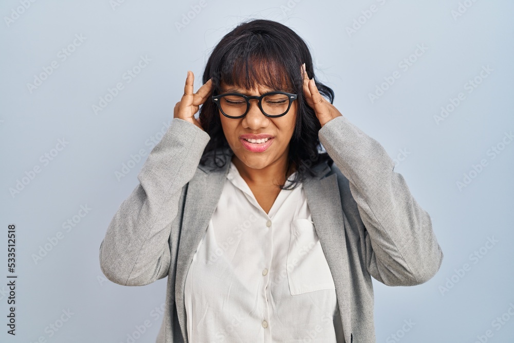 Hispanic woman standing over isolated background with hand on head for pain in head because stress. suffering migraine. Hispanic woman standing over isolated background with hand on head for pain in head because stress. suffering migraine.