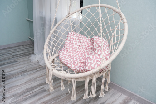 Hanging macrame chair in boho style in the lounge and relax room. photo