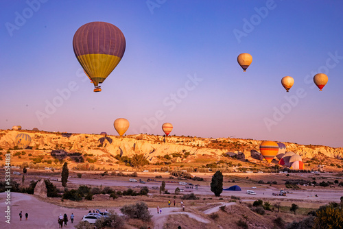 flight of hot air balloons in the morning blue sky over the goreme valley in Cappadocia, horizontal