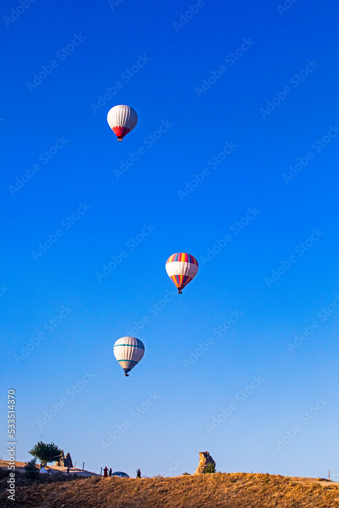 hot air balloons in the morning blue sky over the goreme valley in Cappadocia, horizontal