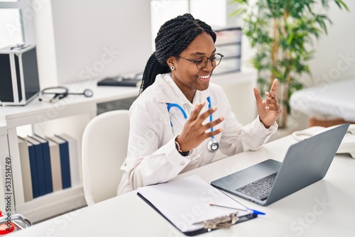 African american woman doctor smiling confident having video call at clinic photo