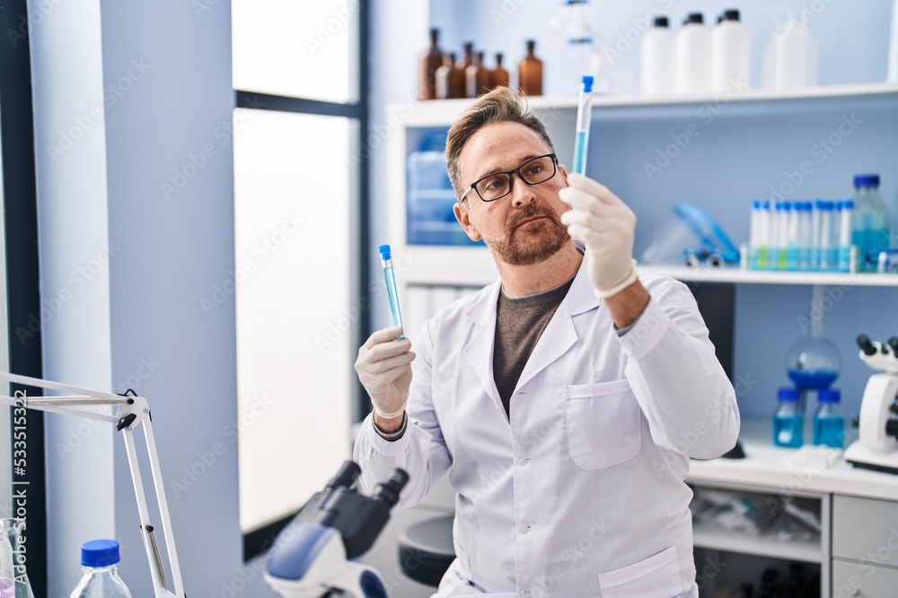 Young caucasian man scientist holding test tubes at laboratory Young caucasian man scientist holding test tubes at laboratory