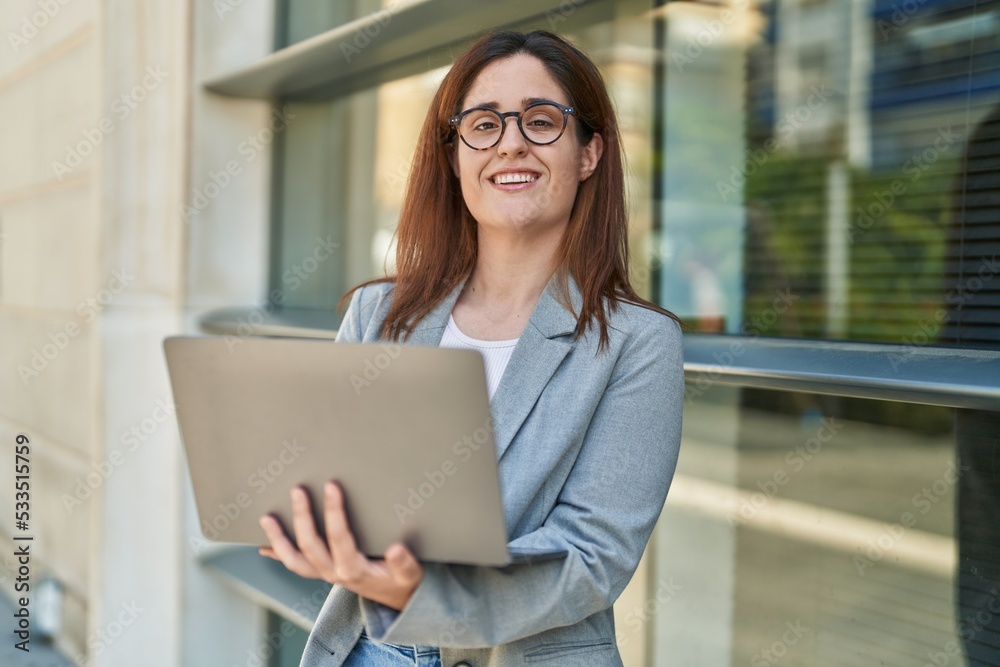 Young woman business worker smiling confident using laptop at street Young woman business worker smiling confident using laptop at street
