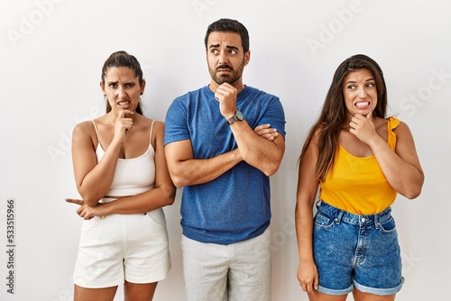 Group of young hispanic people standing over isolated background thinking worried about a question  concerned and nervous with hand on chin