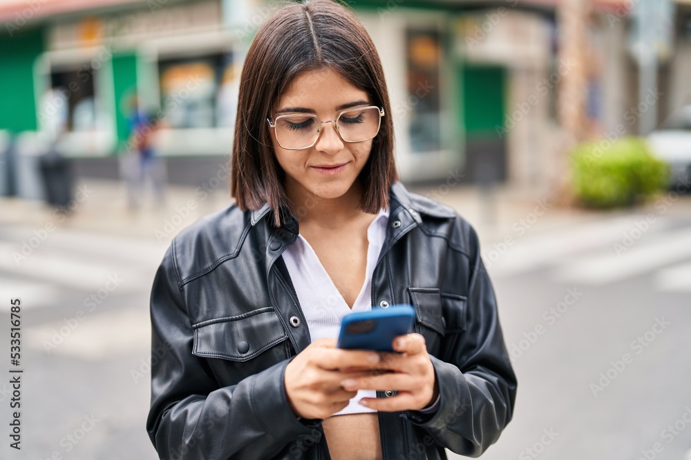 Young beautiful hispanic woman smiling confident using smartphone at street