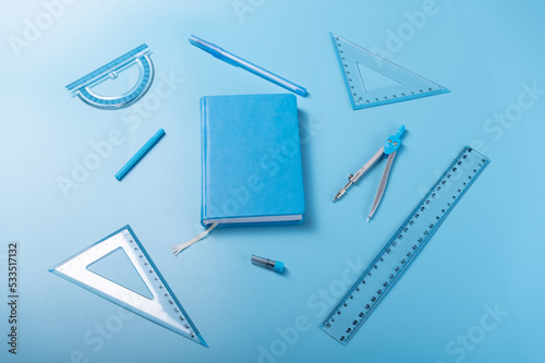 Blue chancery blue background. Monotonous blue background. Blue notepad and school items. Top view at an angle. photo