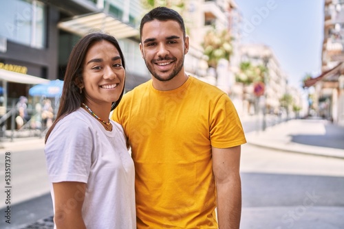 Young latin couple smiling happy and hugging standing at the city.