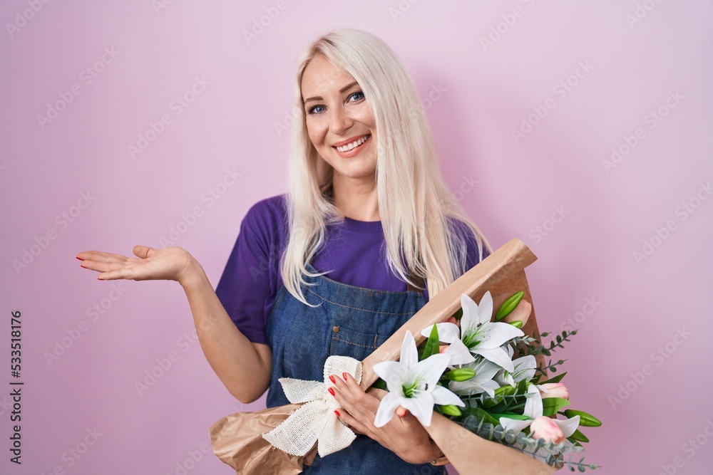 Caucasian woman holding bouquet of white flowers pointing aside with hands open palms showing copy space, presenting advertisement smiling excited happy