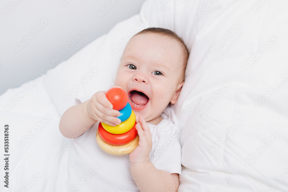 A kid with a wooden pyramid . Happy baby. Children's toys. A kid with a wooden pyramid . Happy baby. Children's toys.