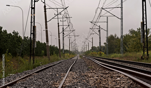 Szyny kolejowe . Widoczne słupy i kable trakcji elektrycznej do napędzania elektrycznych pociągów .