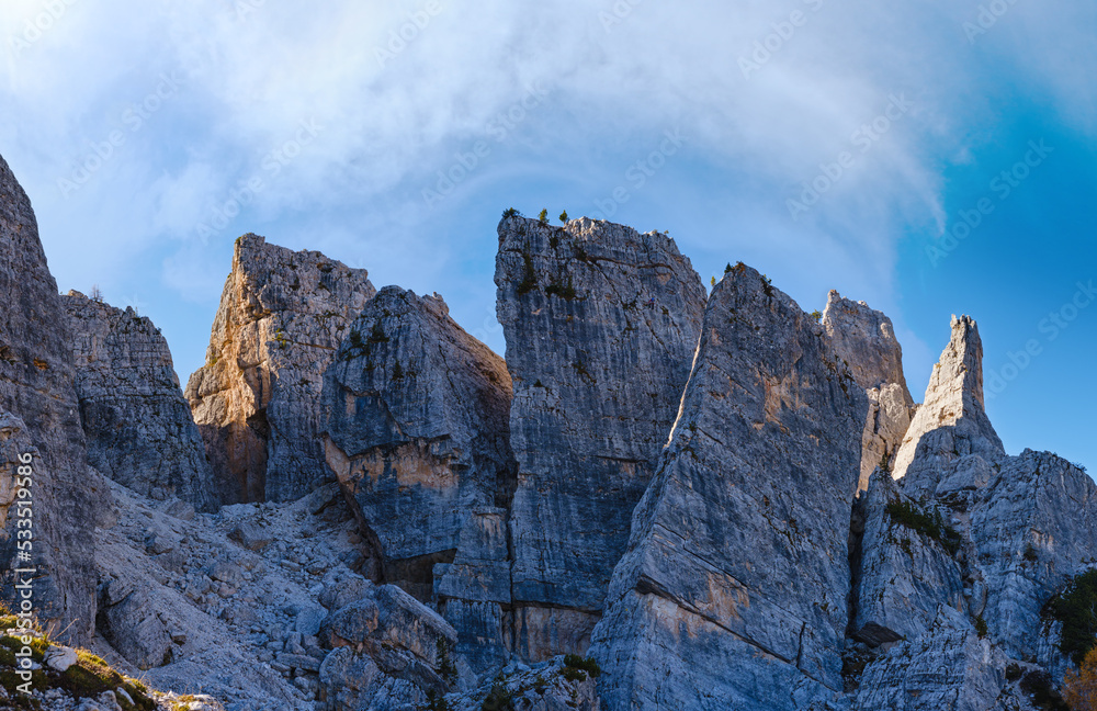 Fototapeta premium Sunny autumn alpine Dolomites rocky mountain scene, Sudtirol, Italy. Cinque Torri (Five pillars or towers) rock famous formation. Climbers unrecognizable.