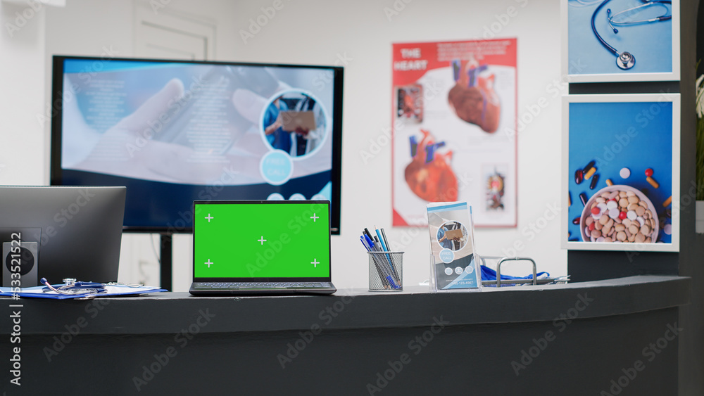 Empty reception desk with greenscreen on laptop display, hospital lobby counter. Computer with blank chroma key screen, isolated mockup template and copyspace background display. Empty reception desk with greenscreen on laptop display, hospital lobby counter. Computer with blank chroma key screen, isolated mockup template and copyspace background display.