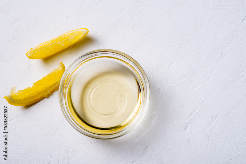 Lemon juice in a bowl. Essence. Lemon slices. White background. Lemon juice in a bowl. Essence. Lemon slices. White background.