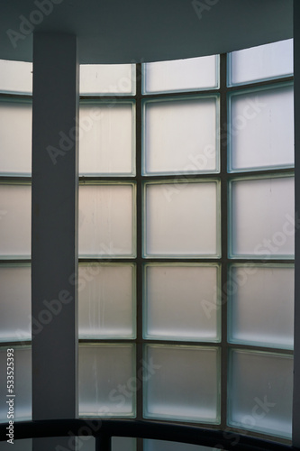 Interior of building looking at opaque of curved window constructed from glass blocks during daytime