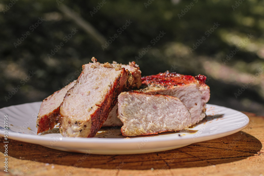 Delicious grilled pork on the plate with fork and knife Delicious grilled pork on the plate with fork and knife