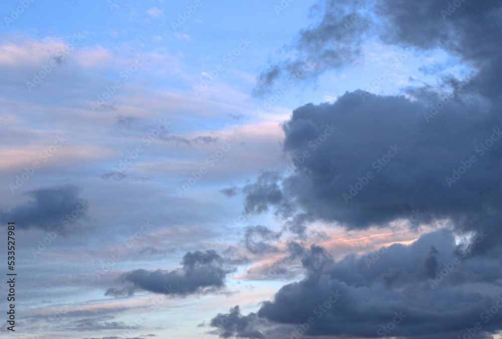 White and dark clouds float towards each other across the blue sky, on the monitor Background Banner Screensaver.