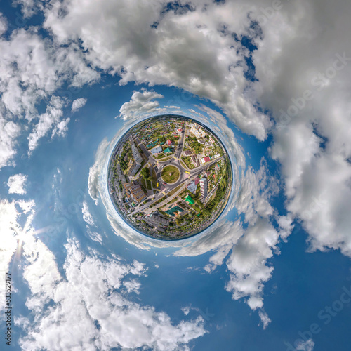 tiny planet in sky with clouds overlooking old town, urban development, historic buildings and crossroads. Transformation of spherical 360 panorama in abstract aerial view.