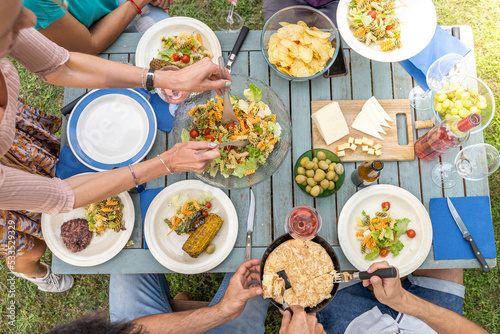 фотографія Multicultural family sitting at wooden table having dinner